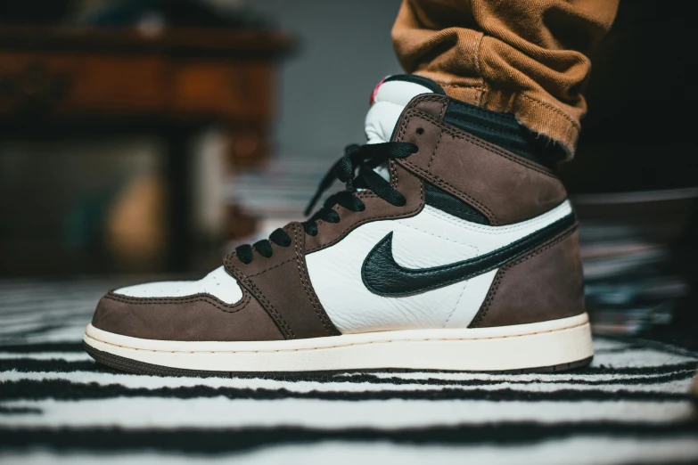 a pair of brown and white sneakers sitting on top of a black and white rug, inspired by Jordan Grimmer, trending on pexels, air jordan 1 high, brown pants, profile shot, chocolate. rugged