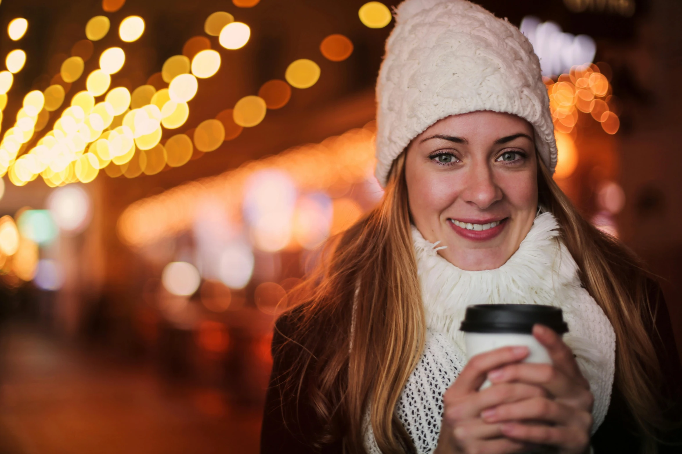 a woman smiles while holding a cup of coffee, by Julia Pishtar, pexels, christmas lights, avatar image, tourist photo, thumbnail