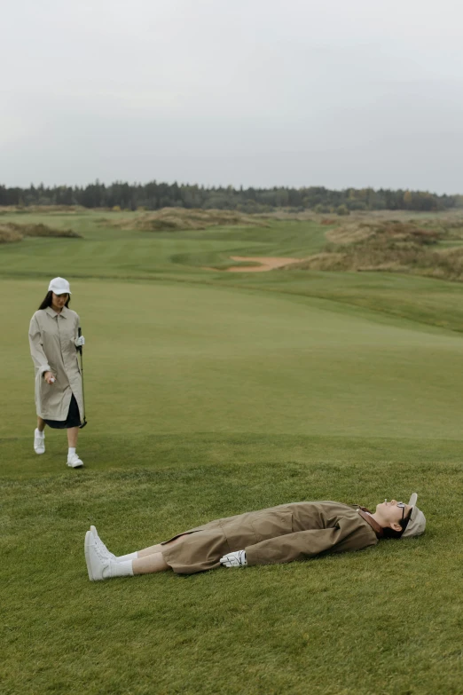 a man laying on the ground next to a woman on a golf course, an album cover, by Fei Danxu, unsplash, omaha beach, gif, fashionable, fatigue