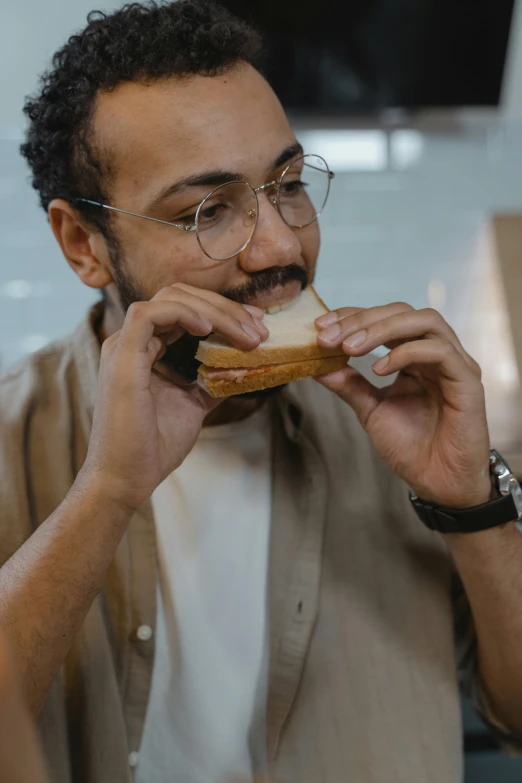 a man sitting at a table eating a sandwich, pexels contest winner, with nerdy glasses and goatee, ashteroth, eating garlic bread, square masculine jaw