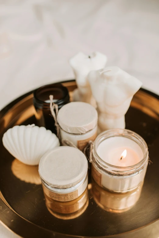 a tray that has some candles on it, a still life, pexels, light cream and white colors, detailed product image, jars, shells