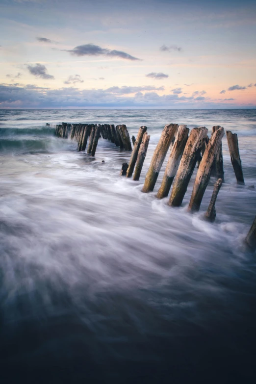 a wooden structure sitting in the middle of a body of water, unsplash contest winner, waves crashing, fallen columns, medium format. soft light, long exposure 8 k