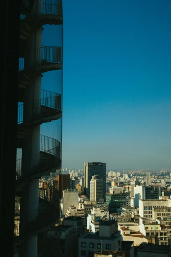 a view of a city from a high rise building, brutalism, buenos aires, spiral staircase, tokio, left profile