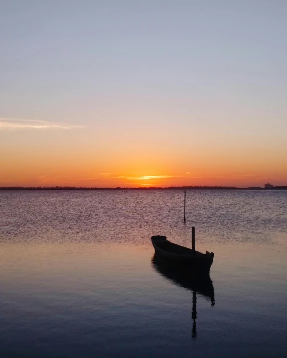 a boat sitting on top of a body of water, a picture, happening, at sunset, hziulquoigmnzhah, best photo