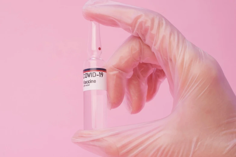 a close up of a person's hand holding a vial, an album cover, trending on pexels, plasticien, pink, syringe, covid, pristine clean design