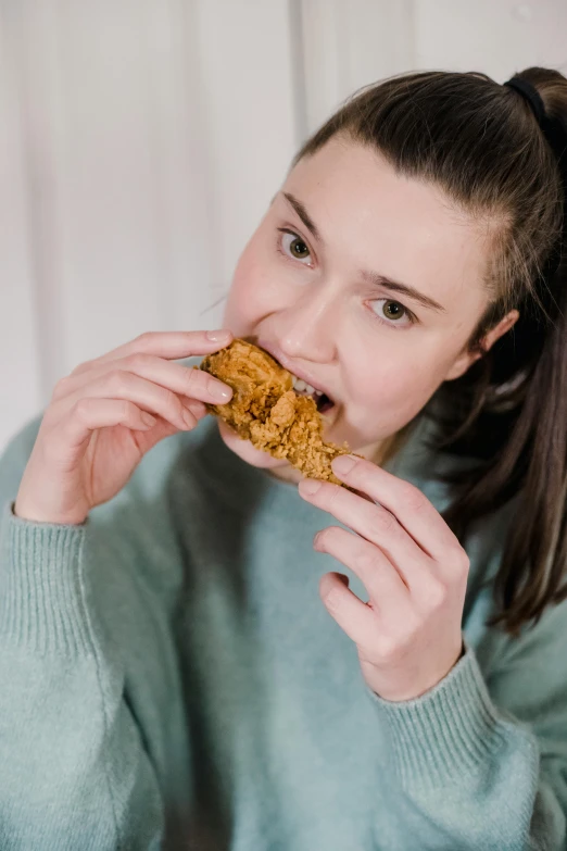 a woman sitting at a table eating a cookie, unrefined gold nugget, crispy quality, sloppy, healthy