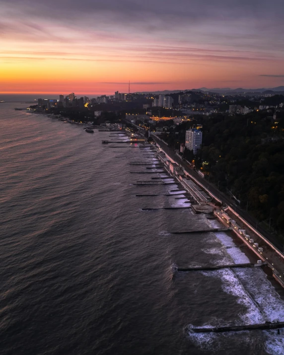 a large body of water next to a beach, by Alexey Venetsianov, pexels contest winner, city sunset, lgbtq, flatlay, lined up horizontally