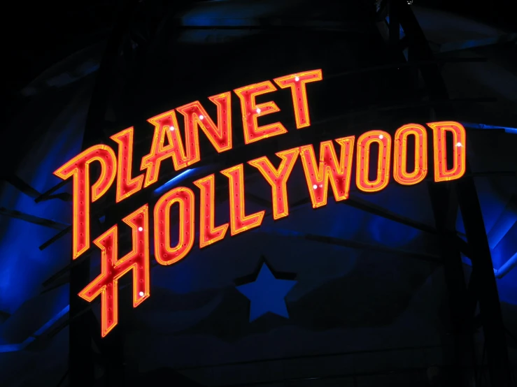 a neon sign that says planet hollywood, pexels, art nouveau, 2 0 0 4 photograph, burt reynolds, avatar image, [ theatrical ]