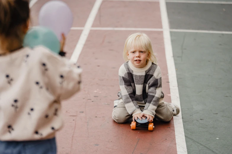 a small child sitting on top of a tennis court, by Anita Malfatti, pexels contest winner, at a birthday party, annoyed, balloon, on a checkered floor