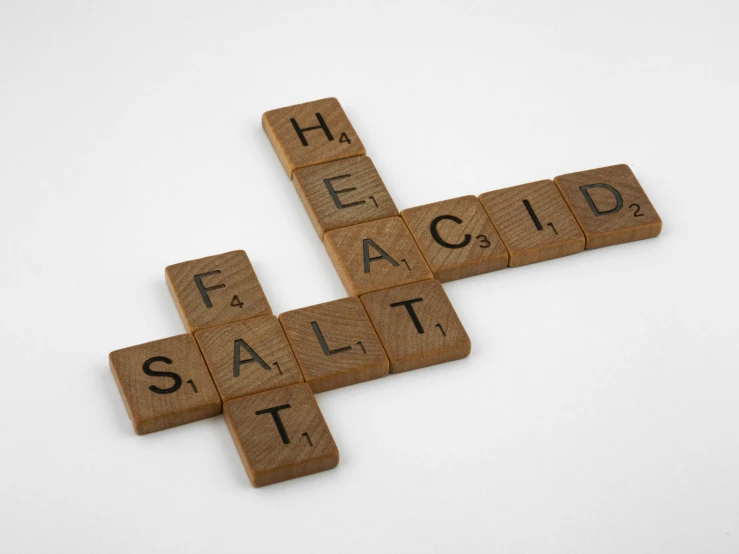 a cross made out of scrabbles on a white surface, an album cover, by Sarah Lucas, pexels, salt effects, acids, healer, eating