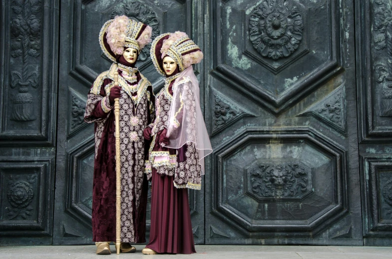 a couple of people that are standing in front of a door, inspired by Quirizio di Giovanni da Murano, pexels contest winner, baroque, jeweled costume, maroon metallic accents, square, gondolas