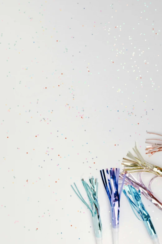 a bunch of toothbrushes sitting on top of a table, poster art, by Nicolette Macnamara, trending on unsplash, visual art, glittering stars scattered about, white paper background, ruffles tassels and ribbons, foil effect