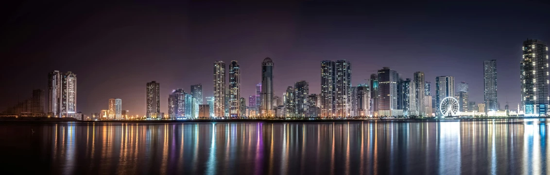 a view of a city at night from across the water, by Jang Seung-eop, pexels contest winner, hyperrealism, panoramic, middle east, shenzhen, gigapixel photo