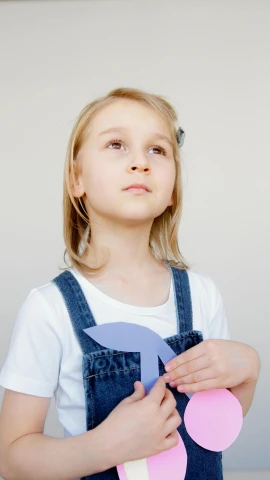 a little girl that is holding a piece of paper, inspired by Elsa Beskow, pexels contest winner, wearing blue jean overalls, 15081959 21121991 01012000 4k, paper airplane, blue whale