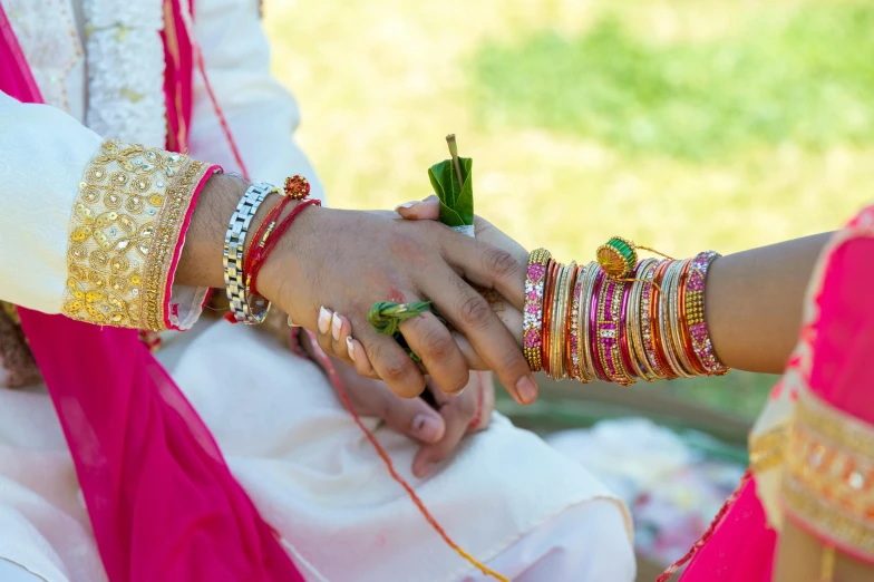 a close up of a person holding a person's hand, samikshavad, white and pink, traditional clothes, thumbnail, vibrant setting