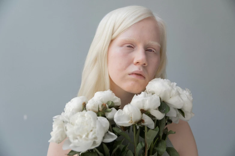 a woman holding a bunch of white flowers, an album cover, inspired by Louisa Matthíasdóttir, hyperrealism, albino skin, prosthetic makeup, trending photo, her face is coated in a whitish