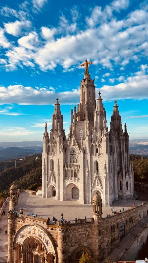 a large building sitting on top of a lush green hillside, an album cover, by Gaudi, pexels contest winner, catholic, marilyn church h, square, barcelo tomas