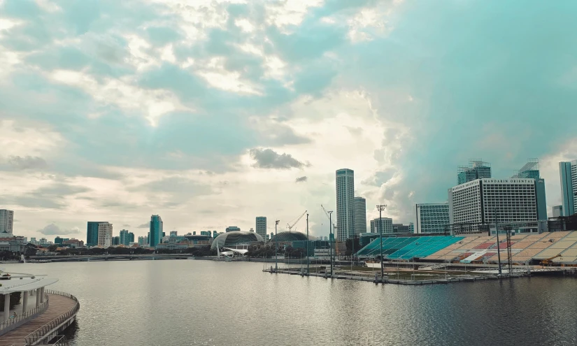 a large body of water with a city in the background, a picture, pexels contest winner, hurufiyya, winnipeg skyline, set on singaporean aesthetic, sunfaded, finland