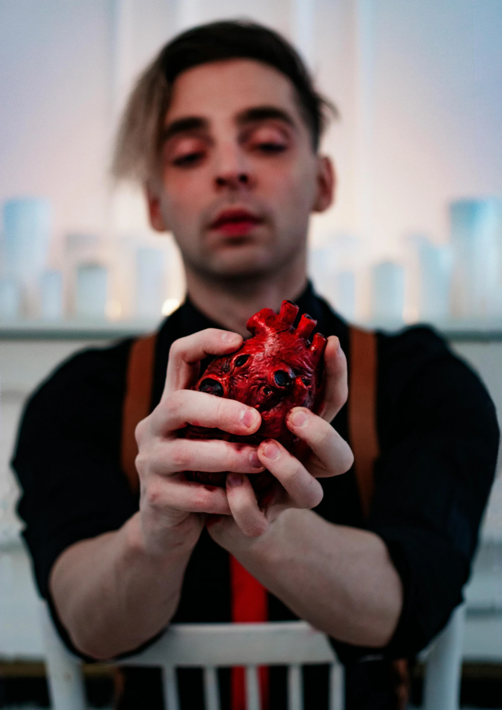 a man holding a heart in his hands, an album cover, by Ignacy Witkiewicz, pexels contest winner, transgressive art, apothecary, non-binary, izombie, full scene shot