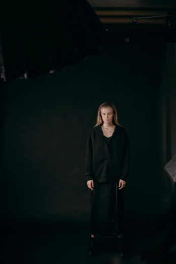 a woman standing in a dark room holding an umbrella, by Sara Saftleven, wearing black clothes, kirsi salonen, portrait sophie mudd, behind the scenes