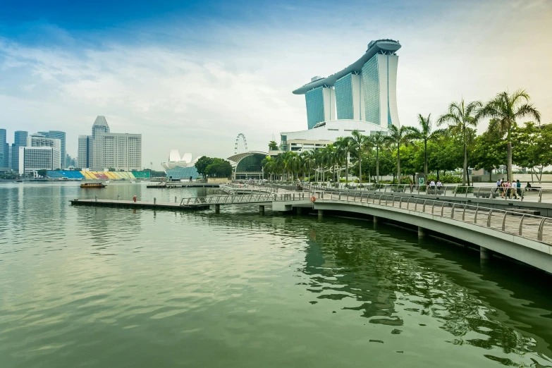 a bridge over a body of water with buildings in the background, by Patrick Ching, pexels contest winner, hurufiyya, set on singaporean aesthetic, on a bright day, water particulate, panoramic