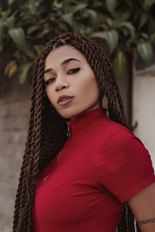 a woman with long hair wearing a red top, an album cover, inspired by Theo Constanté, trending on pexels, twisted braids, portrait mode photo, loosely cropped, in style of nadine ijewere