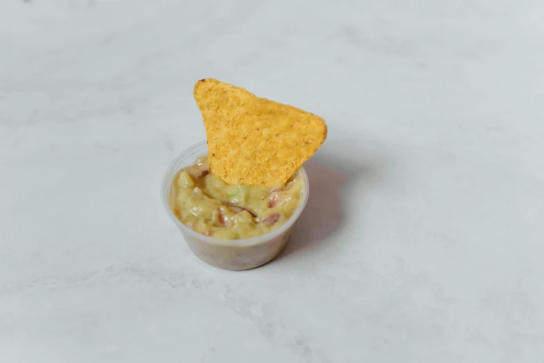 a bowl of guacamole with a tortilla chip in it, a picture, by Nicolette Macnamara, miniature product photo, mac and cheese, top lid, on a pale background