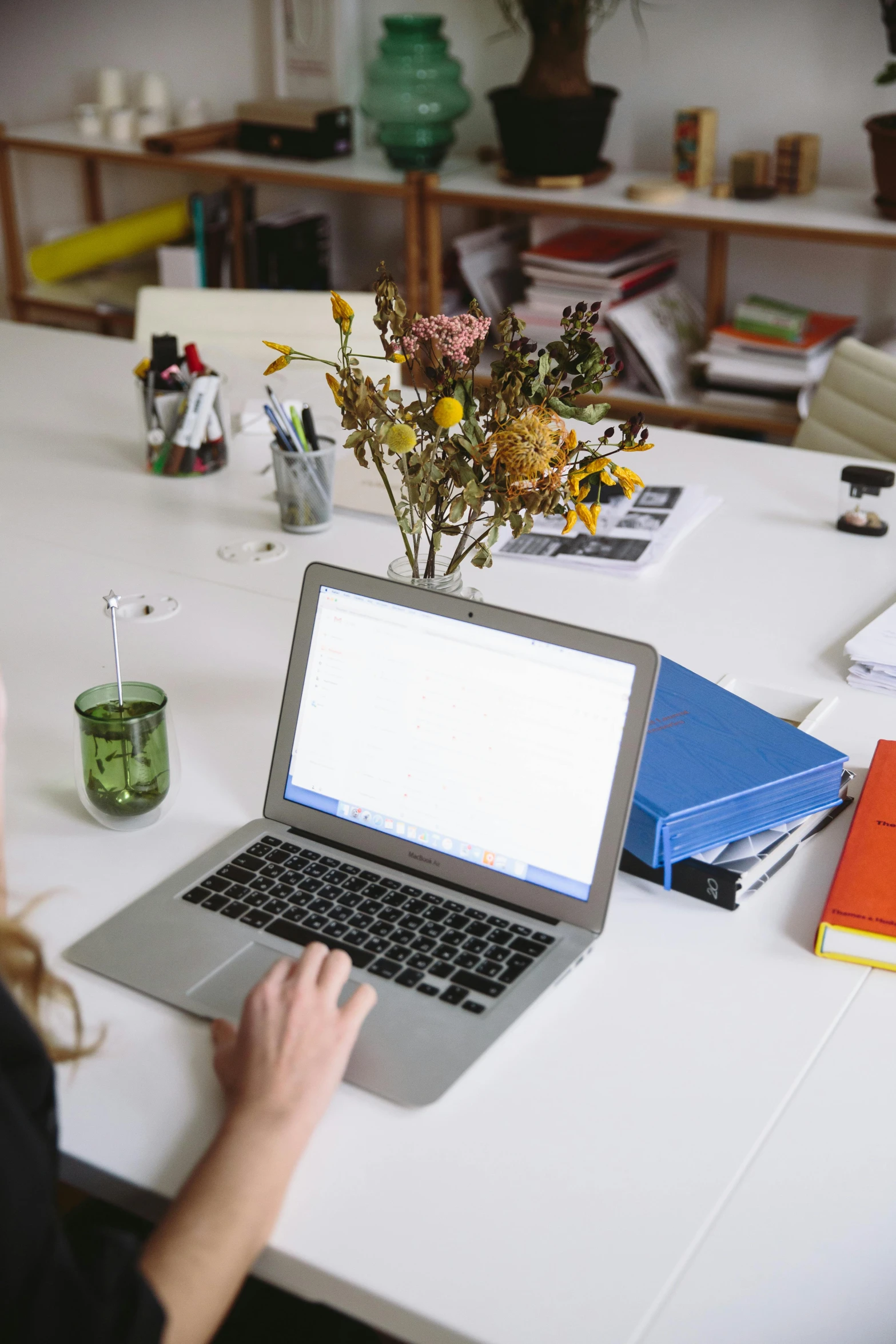 a woman sitting at a table with a laptop, curated collections, fzd school of design, multiple stories, high-quality photo