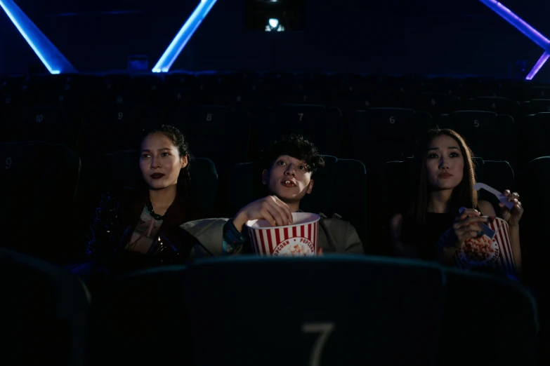 a group of people sitting in a movie theater, a hologram, pexels, hyperrealism, cai xukun, cinestill 800t 50mm eastmancolor, cinematic. by leng jun, people at night