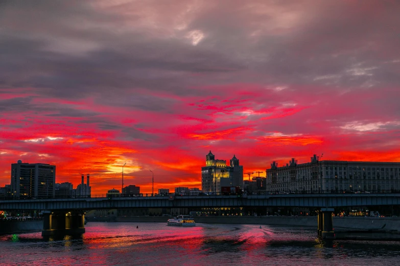 a bridge over a body of water with a city in the background, by Sven Erixson, pexels contest winner, romanticism, blood red sky, in moscow centre, fire in the sky, slide show