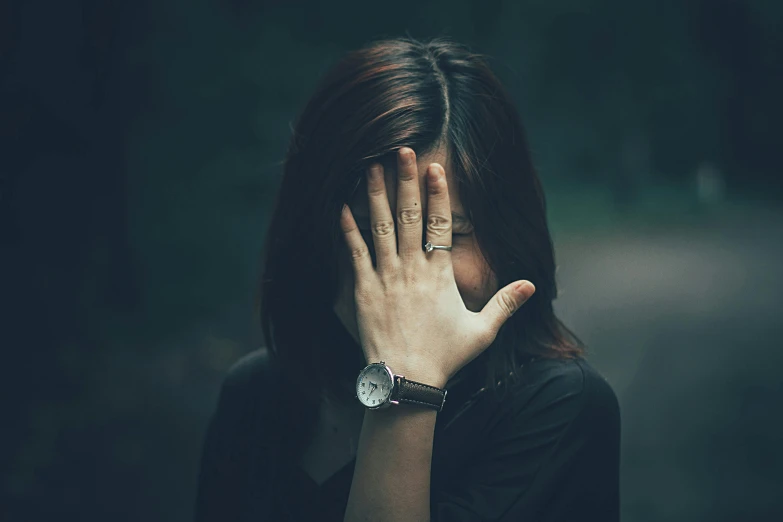 a woman covering her face with her hands, pexels contest winner, girl with dark brown hair, wearing a watch, an emo girl, greeting hand on head