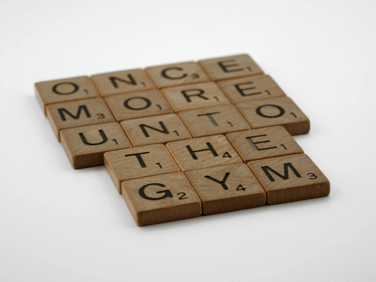 a couple of scrabbles sitting on top of each other, by Emma Andijewska, pexels contest winner, letterism, background a gym, brown, once upon a time, no - text no - logo