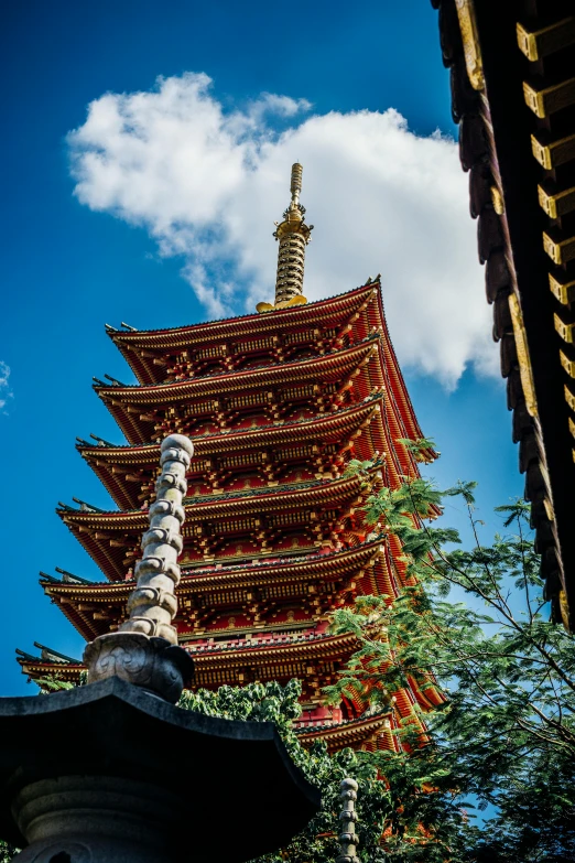 a tall pagoda sitting in the middle of a lush green forest, inspired by Kanō Hōgai, unsplash, cloisonnism, red - yellow - blue building, japanese downtown, blue sky, shot with sony alpha