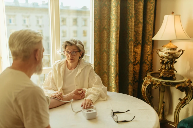 a man and a woman sitting at a table, by Emma Andijewska, pexels contest winner, renaissance, with a stethoscope, a blond, aging, rectangle