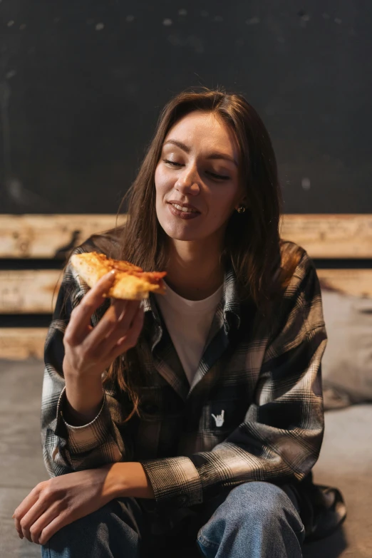 a woman sitting on the floor eating a slice of pizza, pexels contest winner, renaissance, wearing a flannel shirt, wearing a turtleneck and jacket, aussie, gif