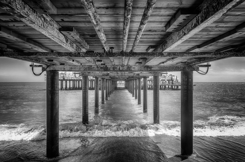 a black and white photo of a pier, a black and white photo, inspired by Thomas Struth, wooden ceiling, splash of color, intricate details and textures, los angeles ca