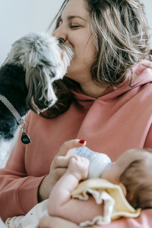 a woman holding a baby and a dog, pexels contest winner, romanticism, multiple details, kiss, australian, toys