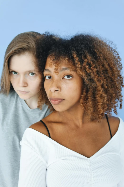 a couple of women standing next to each other, by Cosmo Alexander, trending on pexels, renaissance, frizzy hair, young teen, looking serious, light-brown skin