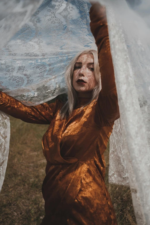 a woman holding an umbrella over her head, an album cover, inspired by Elsa Bleda, pexels contest winner, blonde girl in a cosmic dress, shit cobwebs and shit, in a silver silk robe, warpaint aesthetic
