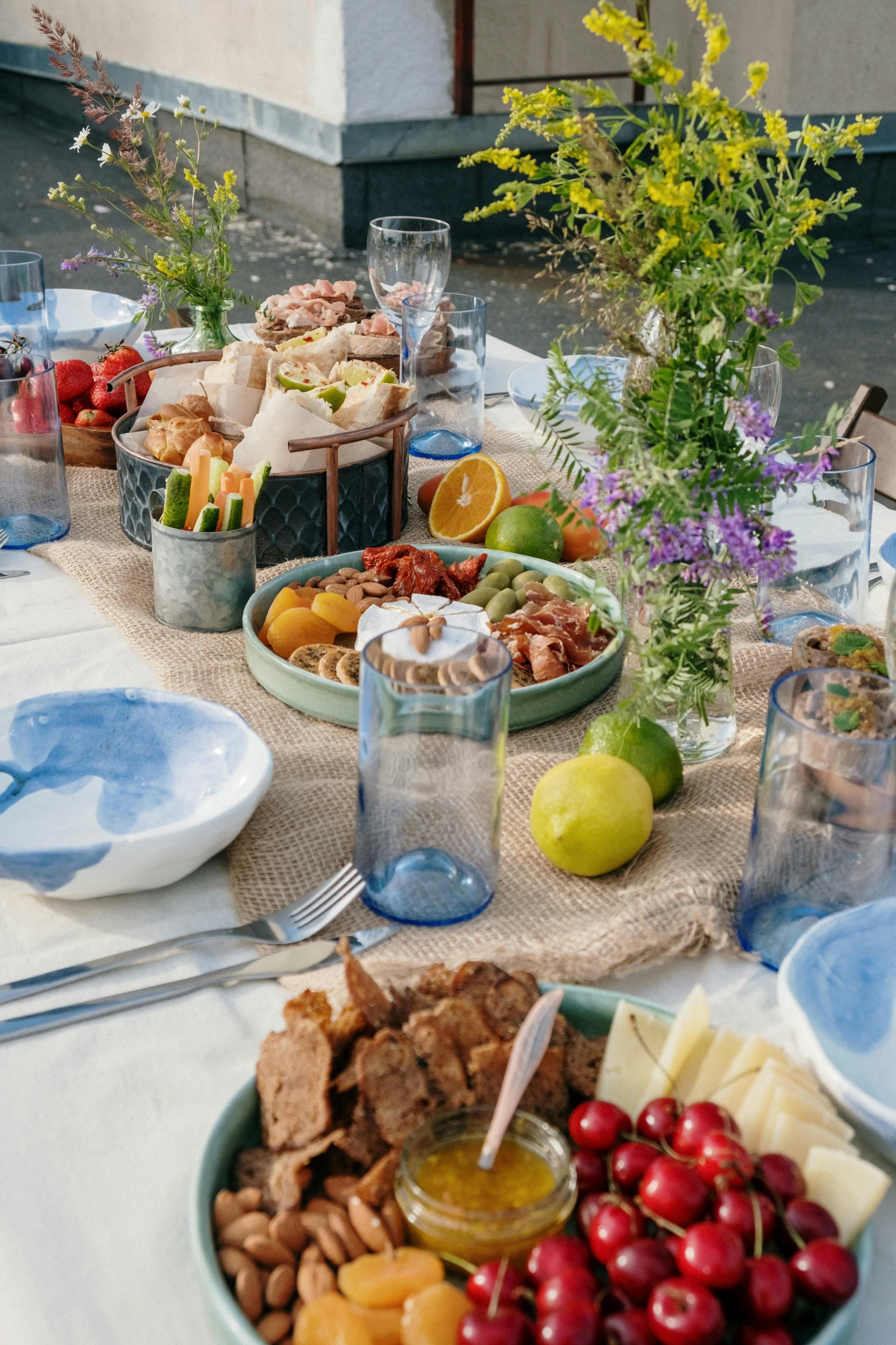 a table that has a lot of food on it, blue themed, midsommar style, profile image, urban setting