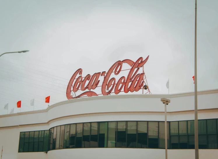 a large coca cola sign on top of a building, by Carey Morris, trending on unsplash, hyperrealism, oscar niemeyer, 1940s photo