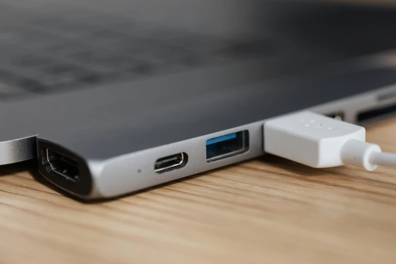 an open laptop computer sitting on top of a wooden table, by Niels Lergaard, unsplash, usb ports, side view close up of a gaunt, rectangular, technical