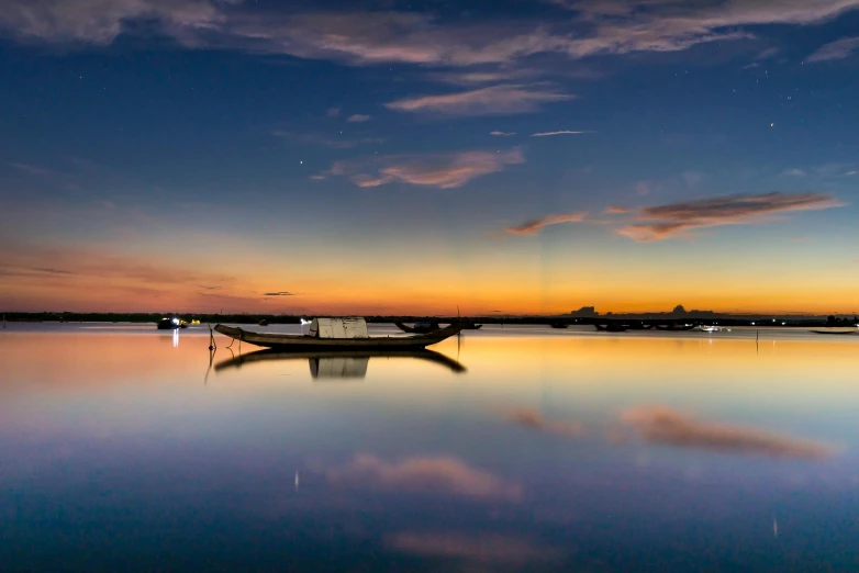 a boat sitting on top of a body of water, by Eglon van der Neer, pexels contest winner, sunset panorama, clear reflection, summer night, lagoon