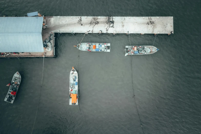 a couple of boats sitting on top of a body of water, by Adam Marczyński, pexels contest winner, tiny ships docking, grey, uav, print ready