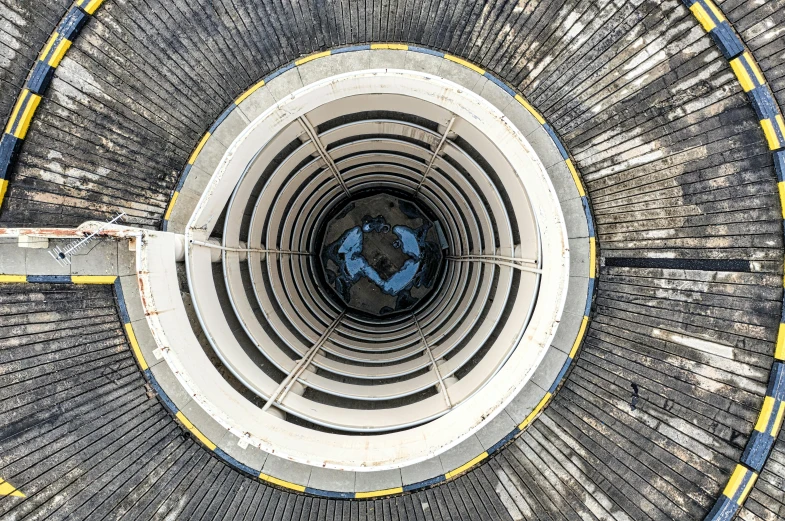 an overhead view of a circular concrete structure, by Jan Rustem, pexels contest winner, nuclear art, an upside down urinal, gigantic tower, black hole, a wooden