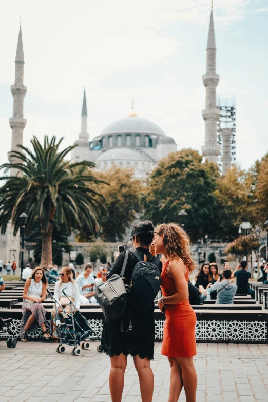 a couple of women standing next to each other, by Niko Henrichon, pexels contest winner, hurufiyya, crowded square, 🚿🗝📝, turkish and russian, couple kissing