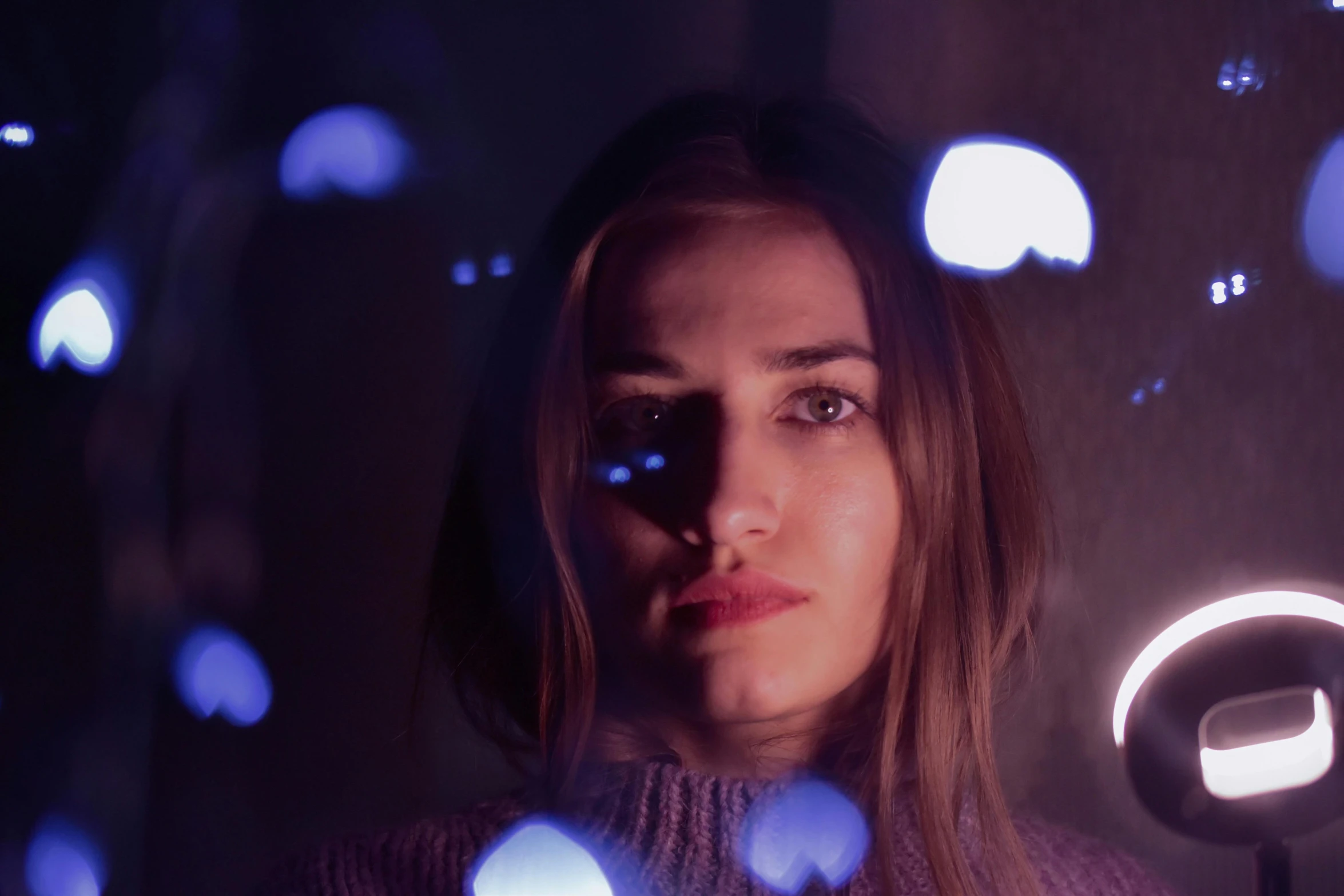 a woman holding a light up to her face, pexels contest winner, pokimane, movie still 8 k, broken lights, purple volumetric lighting