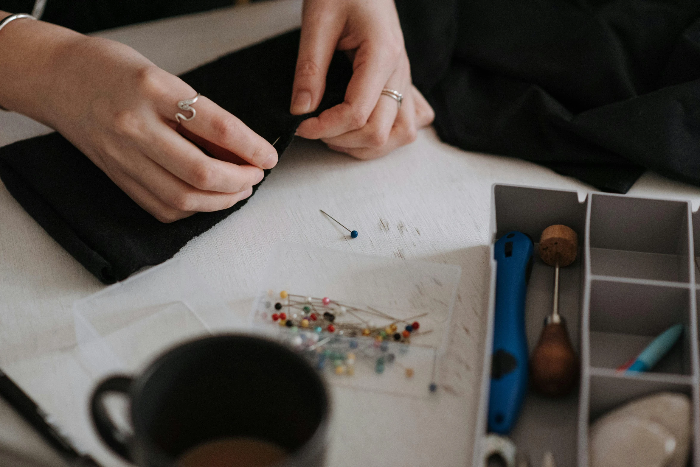 a person sitting at a table working on something, a cross stitch, trending on pexels, sapphire butterfly jewellery, exploded parts assembly, pins of light, maintenance photo