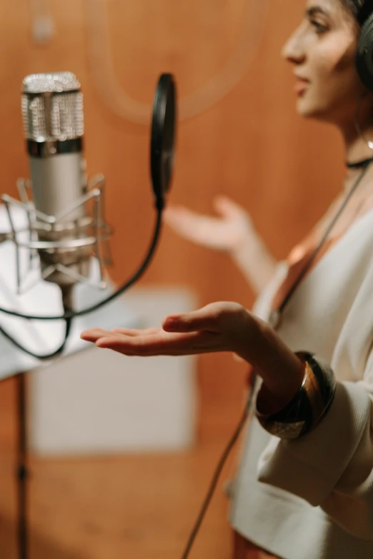 a woman standing in front of a microphone, an album cover, by Gavin Hamilton, trending on pexels, white sleeves, studio recording, dialogue, movie scene close up