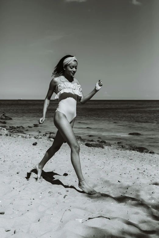 a black and white photo of a woman on the beach, inspired by Bunny Yeager, unsplash, renaissance, girl running, in retro colors, white body, medium format